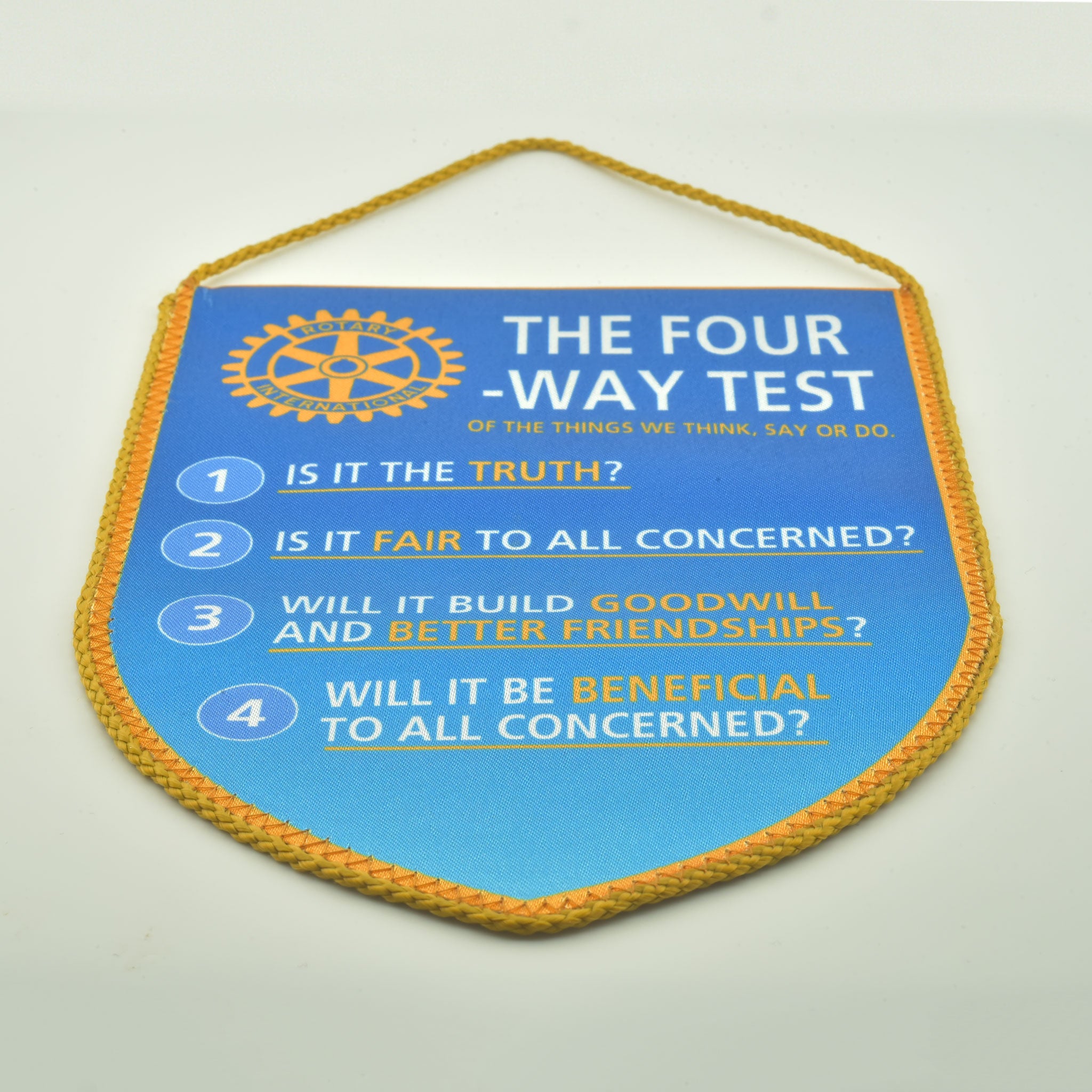 Fanion textil de culoare albastru deschis cu logo-ul si insemnele Rotary Club, agatat pe suport decorativ.