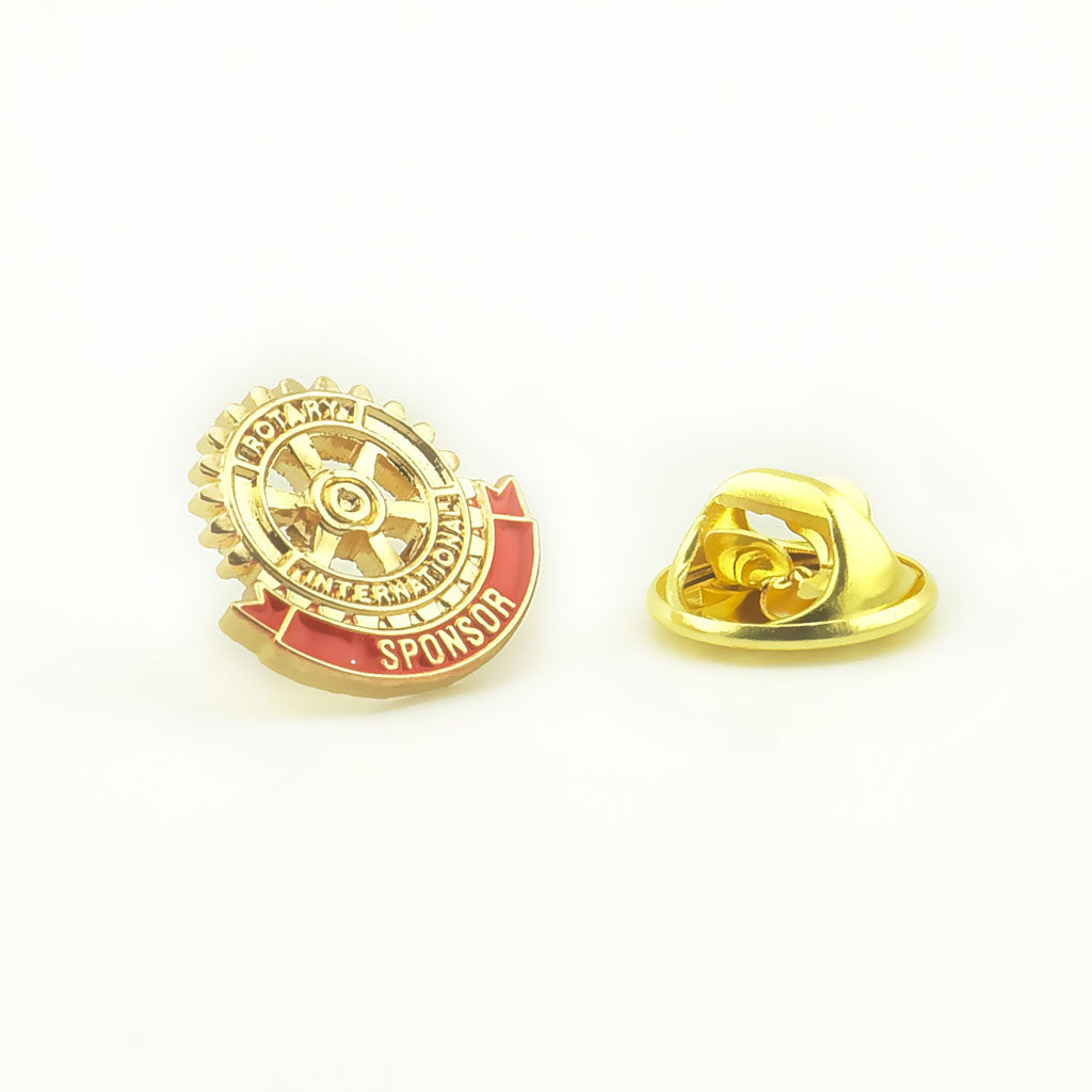 Insigna rotunda Rotary metalica aurie pentru rever prezentata alaturi de sistemul sau de prindere tip fluturas.