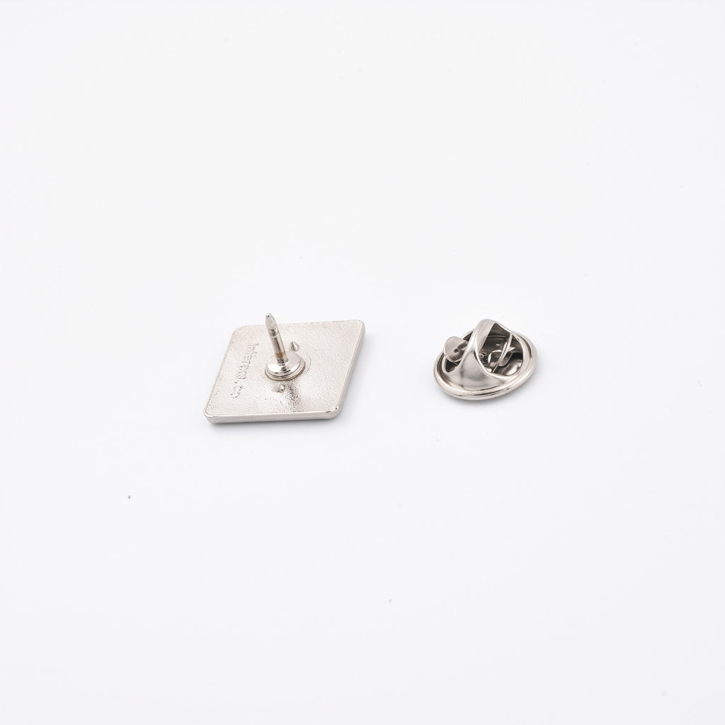 Insigna metalica personalizabila de forma patrata, finisaj argintiu nichelat de 15x15 mm, cu ac si clema fluture pentru fixare pe haine.