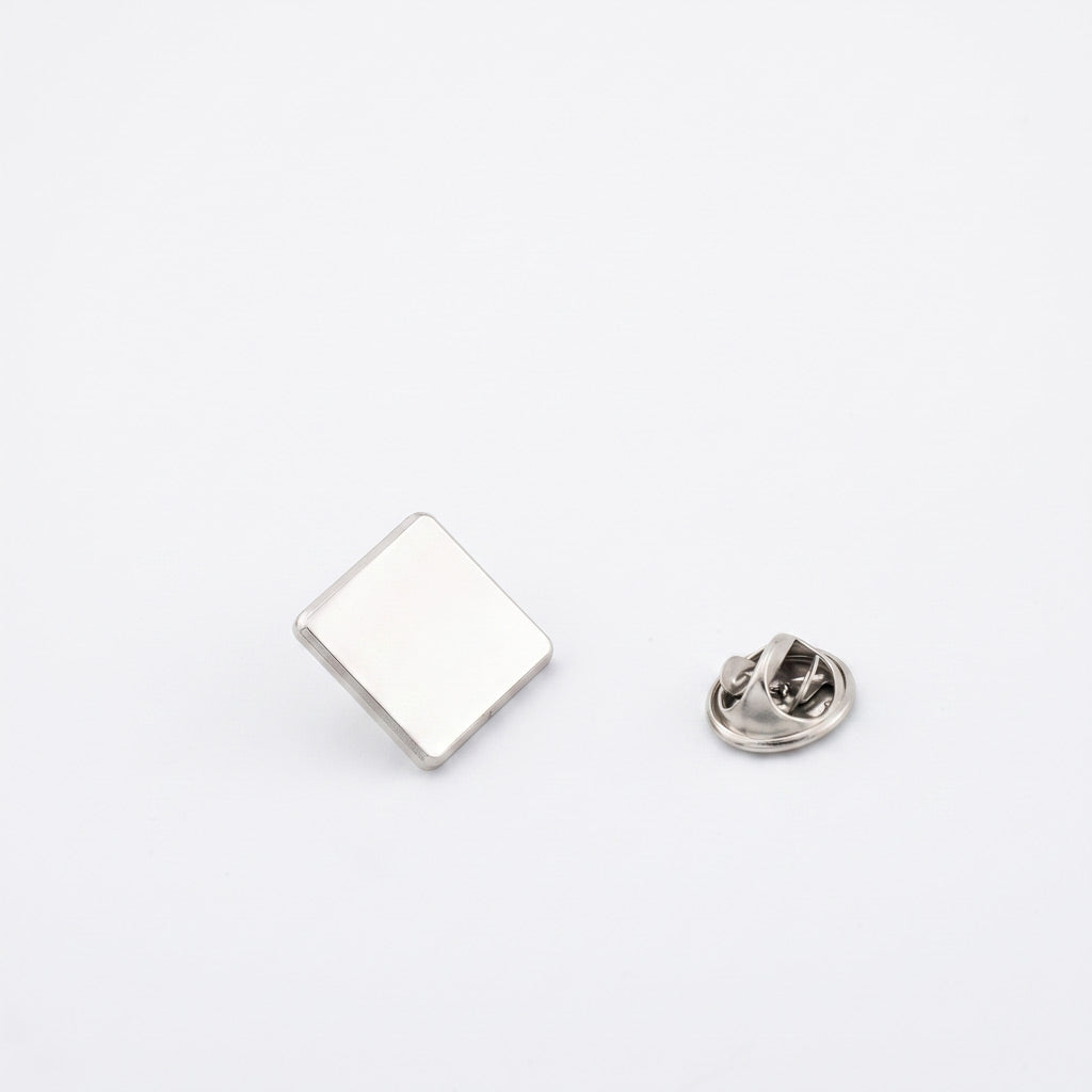 Insigna metalica personalizabila de forma patrata, finisaj argintiu nichelat de 15x15 mm, cu ac si clema fluture pentru fixare pe haine.