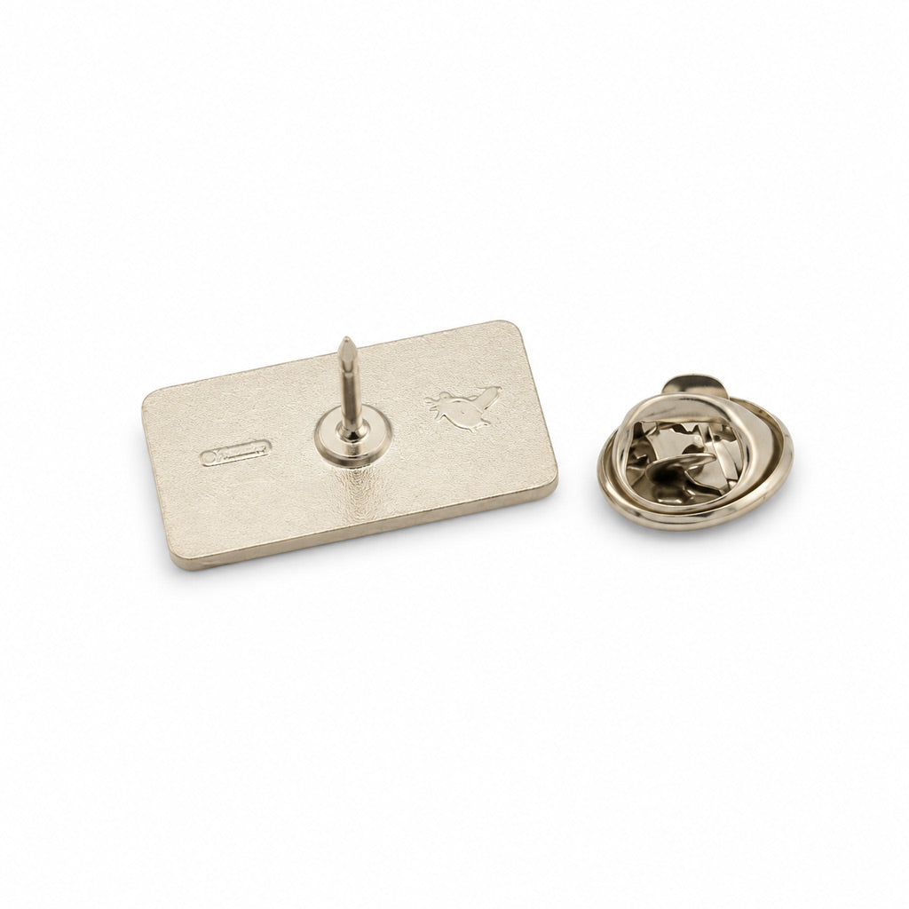 Insigna metalica personalizabila din gama silver cu forma dreptunghiulara si dimensiune de 2.5x1.2 cm, dotata cu ac de siguranta si clema fluture argintie.