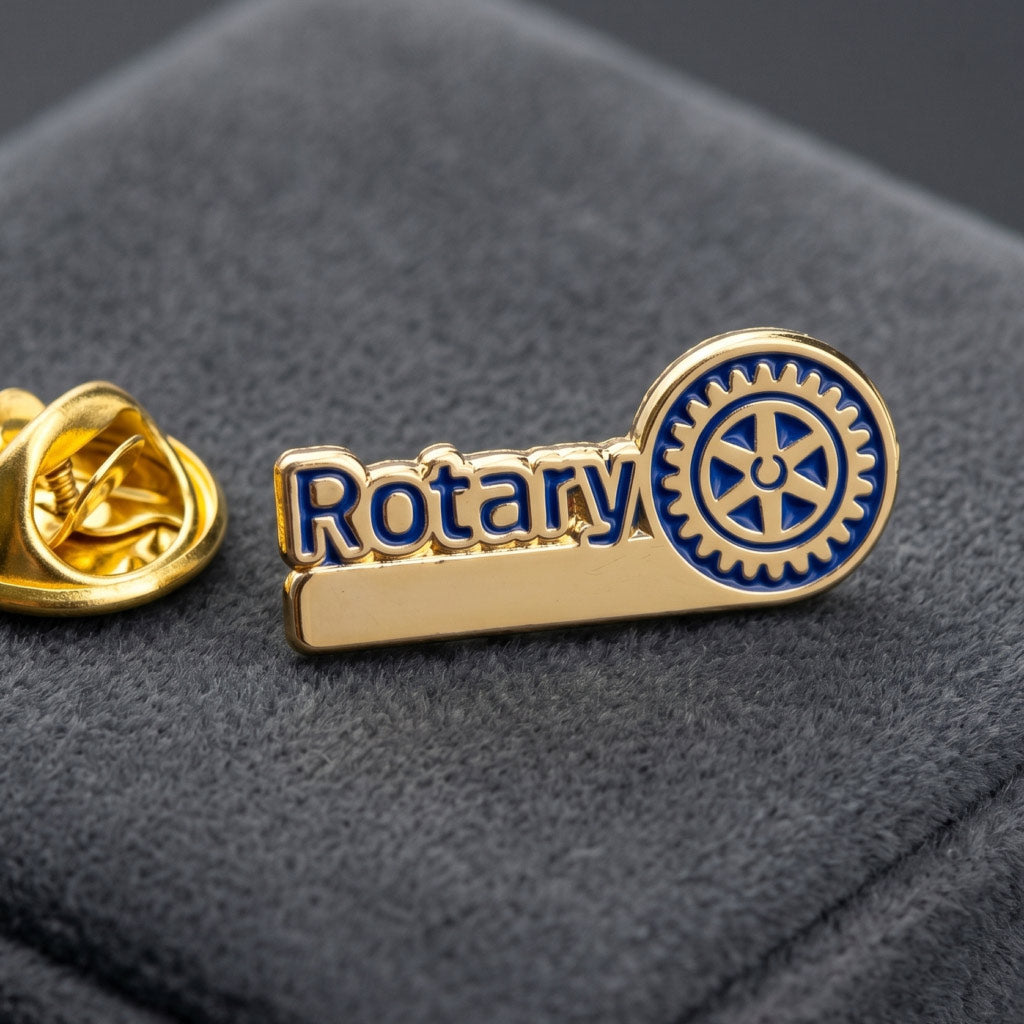 Insigna metalica Rotary nepersonalizata asezata pe un suport textil texturat de prezentare.