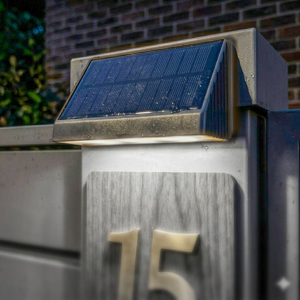 Dispozitiv modern de iluminat solar pentru numărul de casă, cu două LED-uri integrate, activat automat la lăsarea serii.