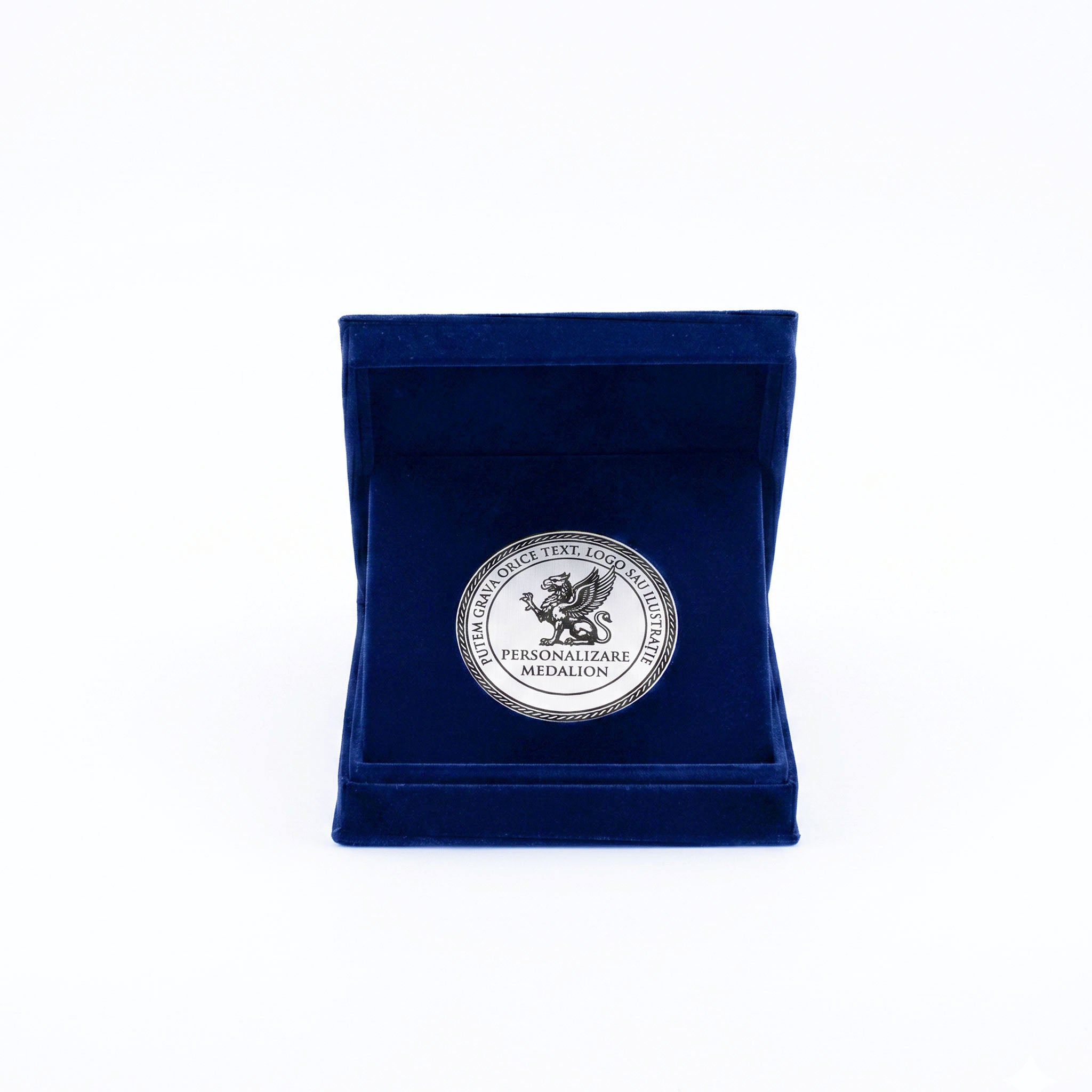 Medalie de 50 mm personalizata prin gravura laser in finisaj argintiu, asezata in cutie de catifea bleu marin.