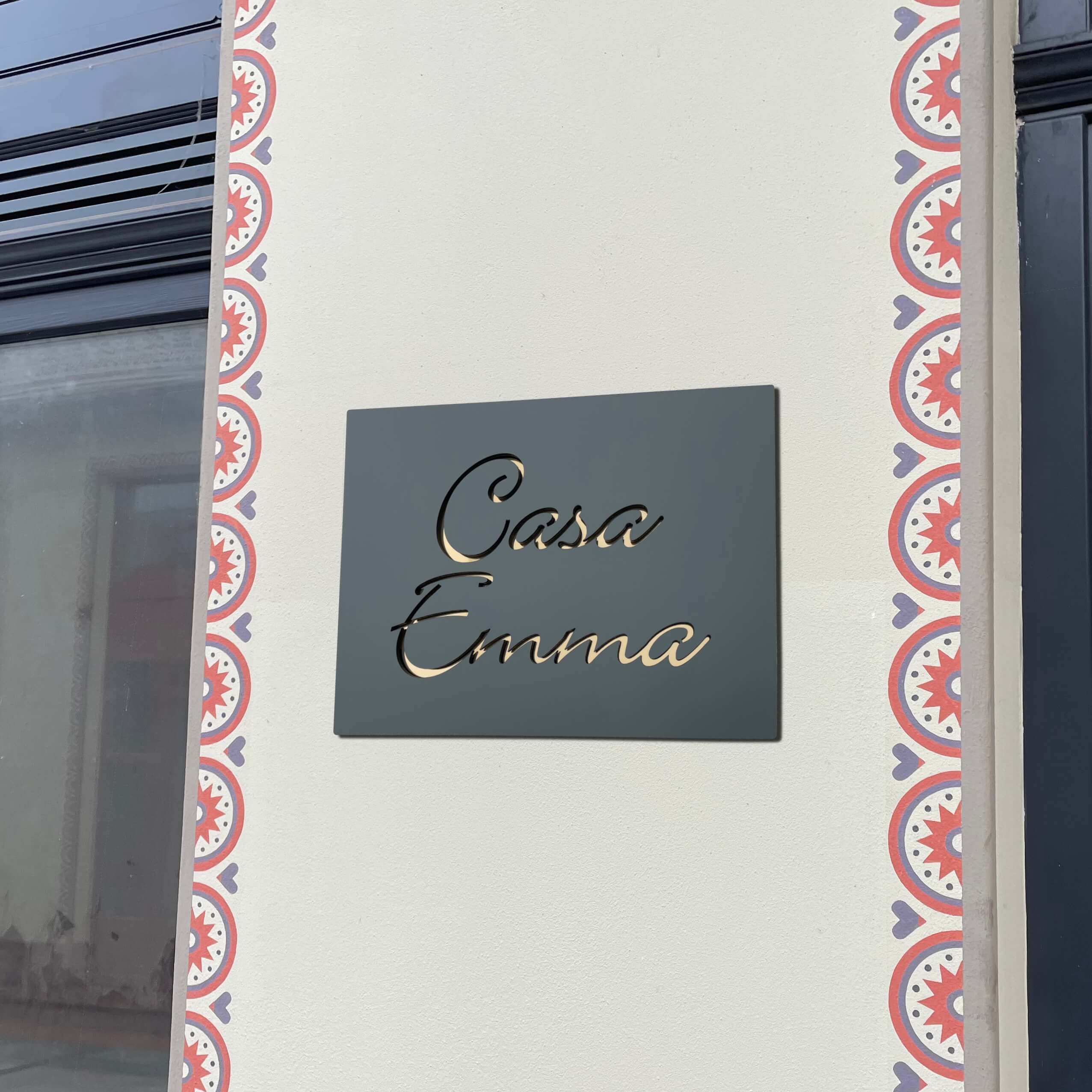 Placuta de casa cu textul Casa Emma pe un perete tencuit
