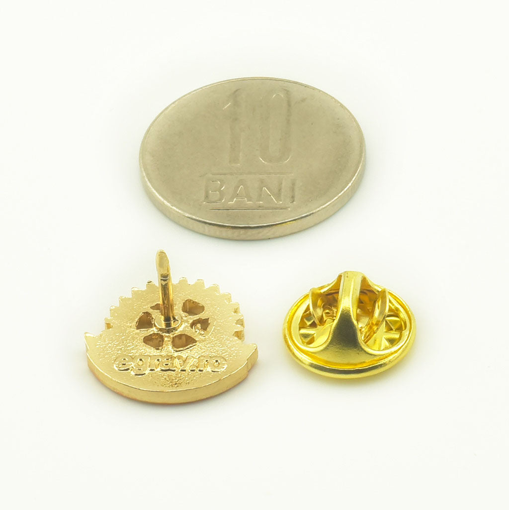 Insigna metalica rotunda cu pin, Rotary International, asezata langa sistemul de inchidere si o moneda de 10 bani pentru scara.