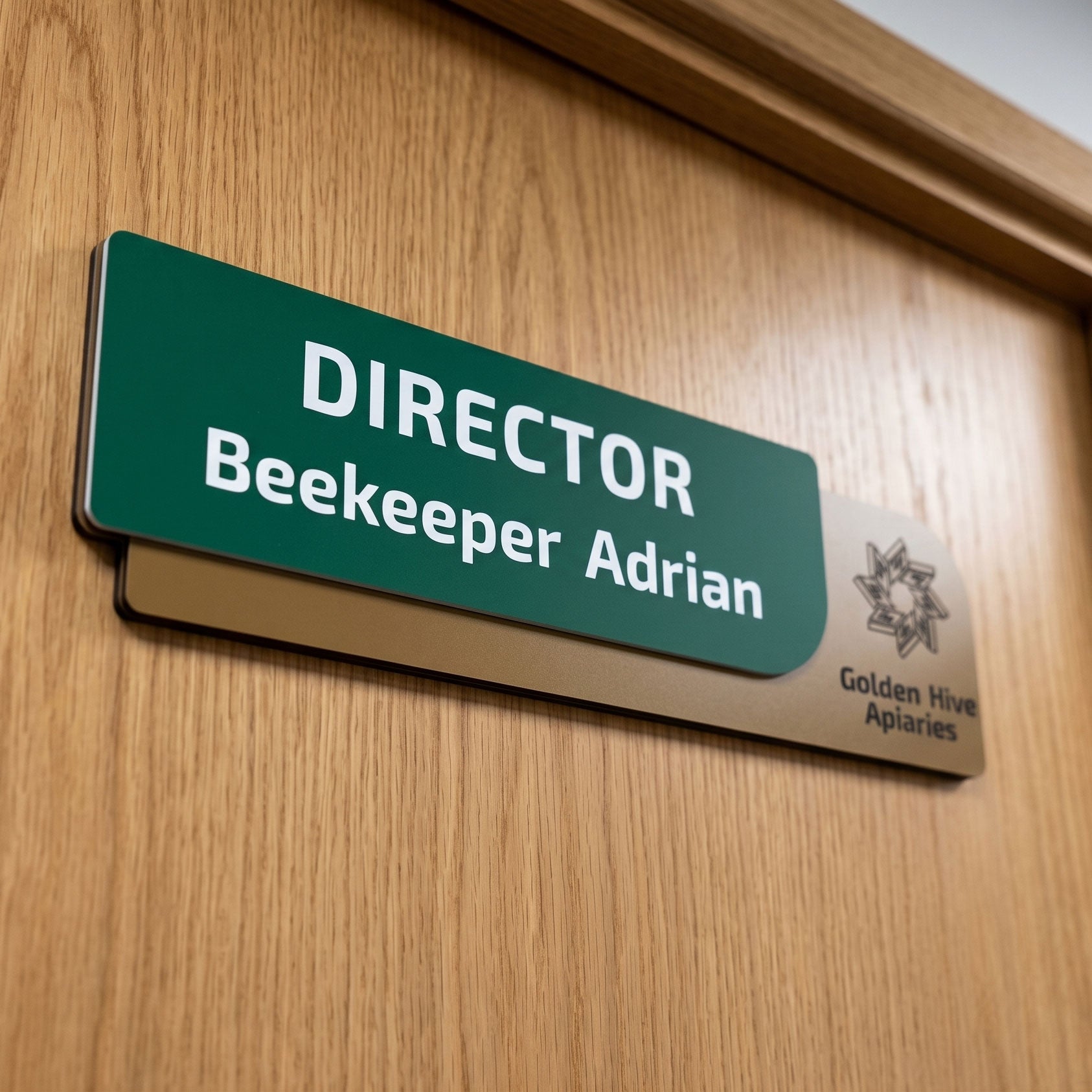 Plăcuță de identificare pentru birou formată din două elemente, cu fața verde închis text „DIRECTOR Beekeeper Adrian” și baza suport cu textură de lemn maro deschis și logo-ul Golden Hive Apiaries pe usa.