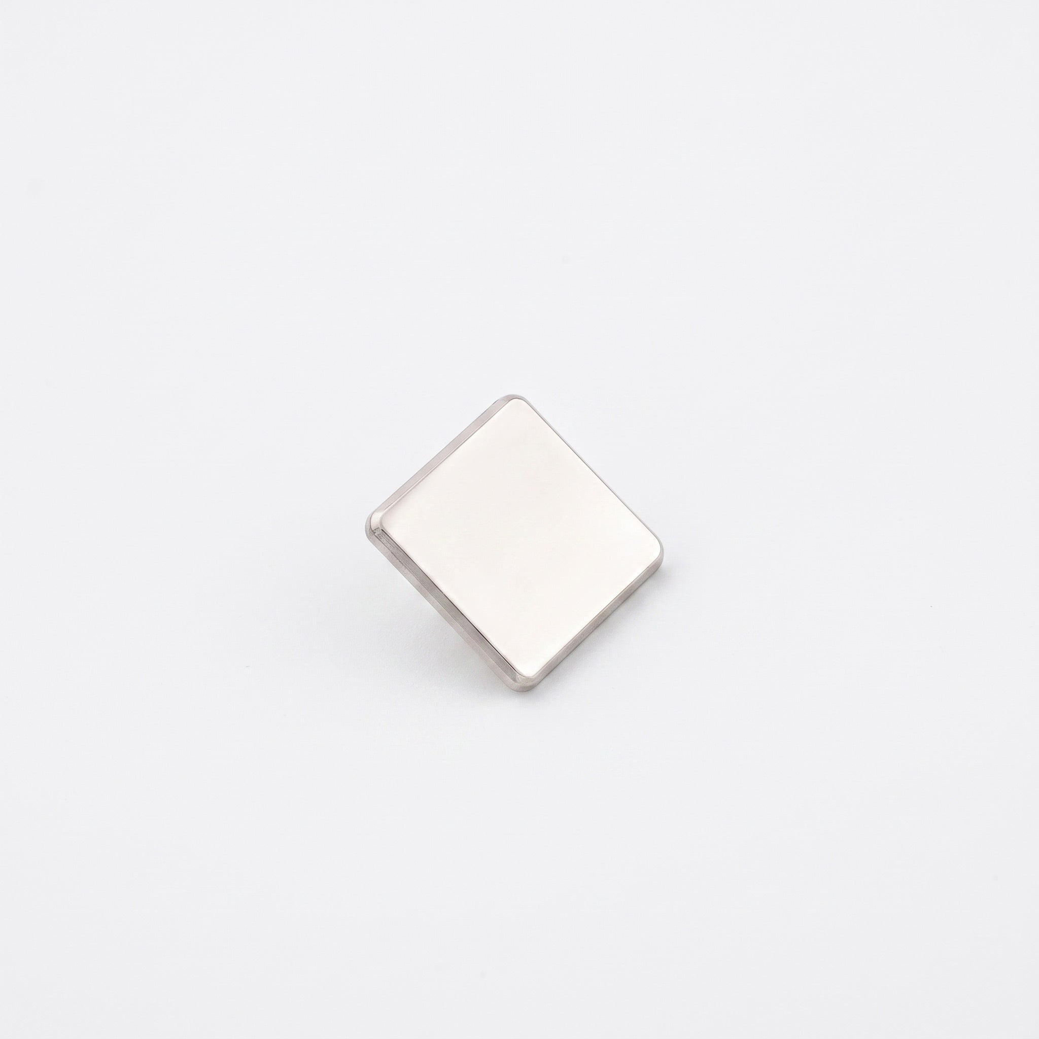 Insigna metalica personalizabila de forma patrata, finisaj argintiu nichelat de 15x15 mm, cu ac si clema fluture pentru fixare pe haine.