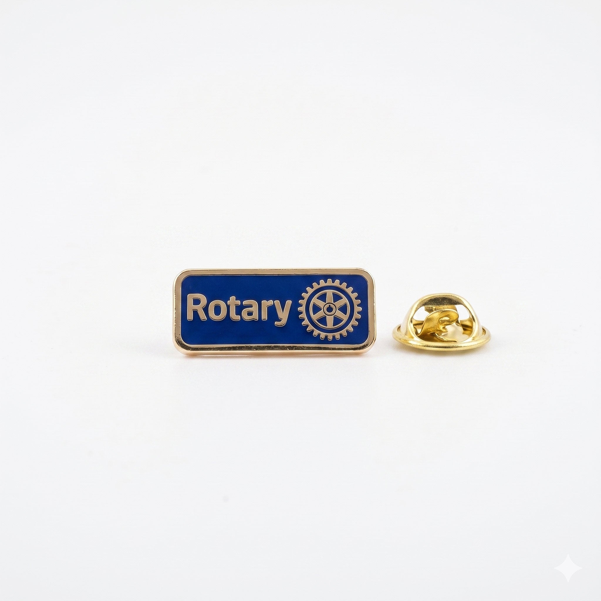 Insigna metalica tip pin Rotary dreptunghiulara cu fundal emailat uniform si text evidentiat prin margini reliefate.