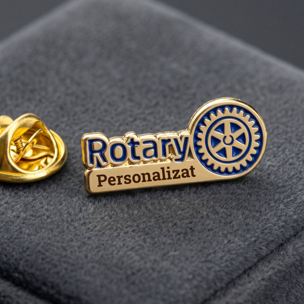 Insigna metalica Rotary personalizata cu text in partea inferioara, expusa pe un material textil elegant.