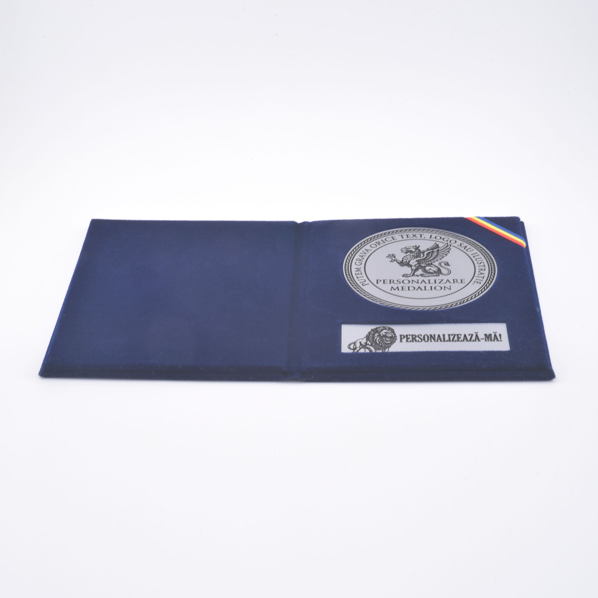 Detaliu medalie personalizată 7 cm finisaj argintiu mat și plăcuță text, în mapă de prezentare tip diplomă din catifea bleu marin.