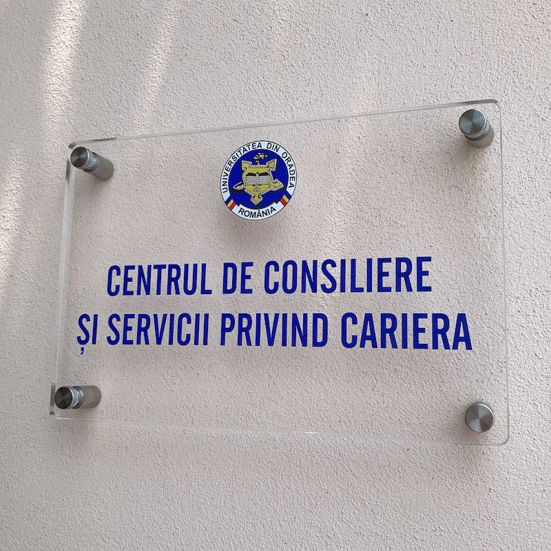 Placa de firma din plexiglass transparent cu textul Centrul de consiliere si servicii privind cariera din Oradea instalat pe un perete
